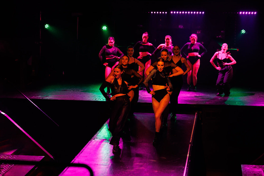 Dancers on a stage with colorful lighting